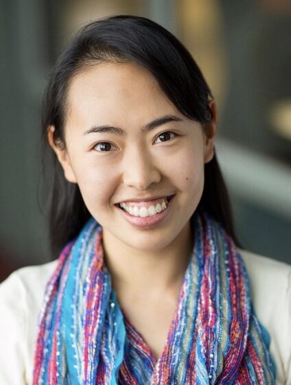Smiling young woman with dark hair wearing a colorful scarf