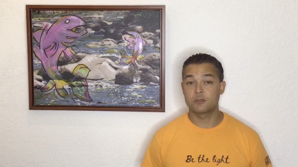 Video preview showing a man in a yellow 'Be the light' t-shirt speaking to camera beside a framed painting of two pink salmon leaping upstream over rocks